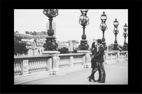 Engaged couple leaning in for a kiss on Pont Alexandre III in Paris