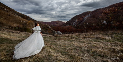 Bride walking in the mountains on a cloudy day